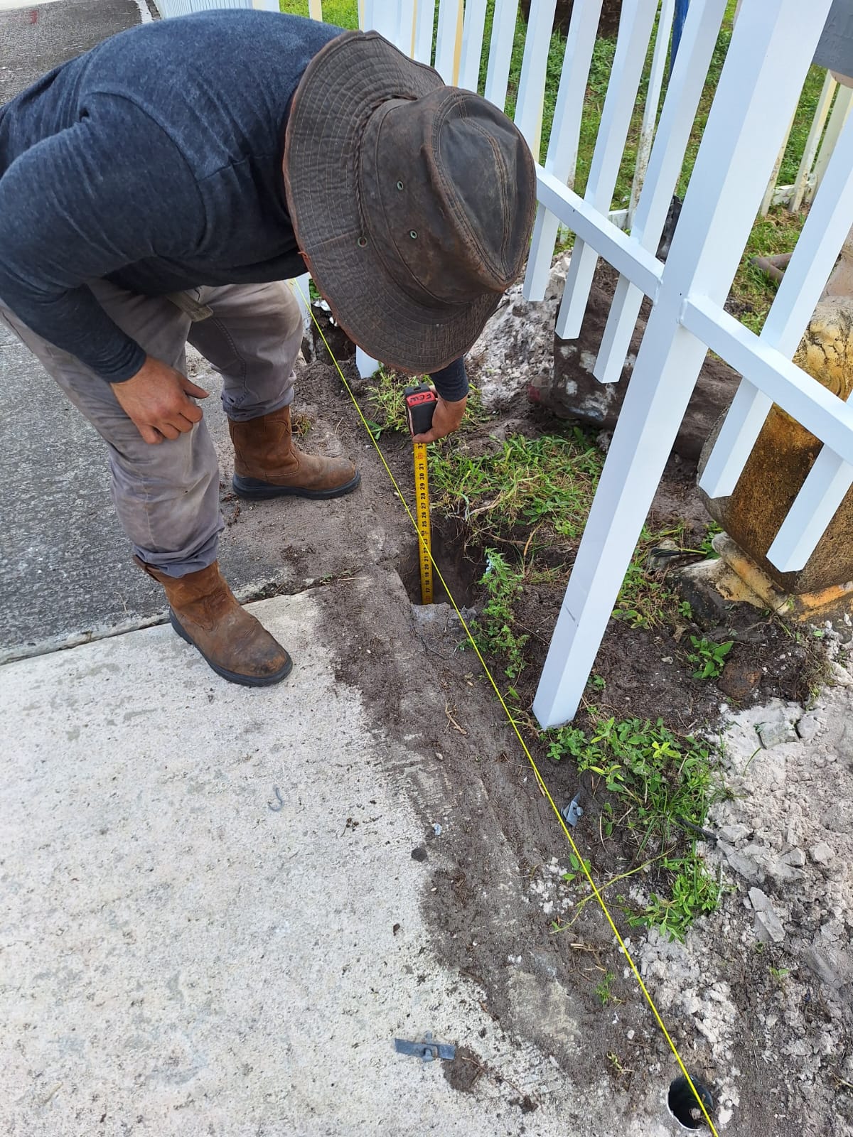 Instalador cavando el hueco para el poste del portón